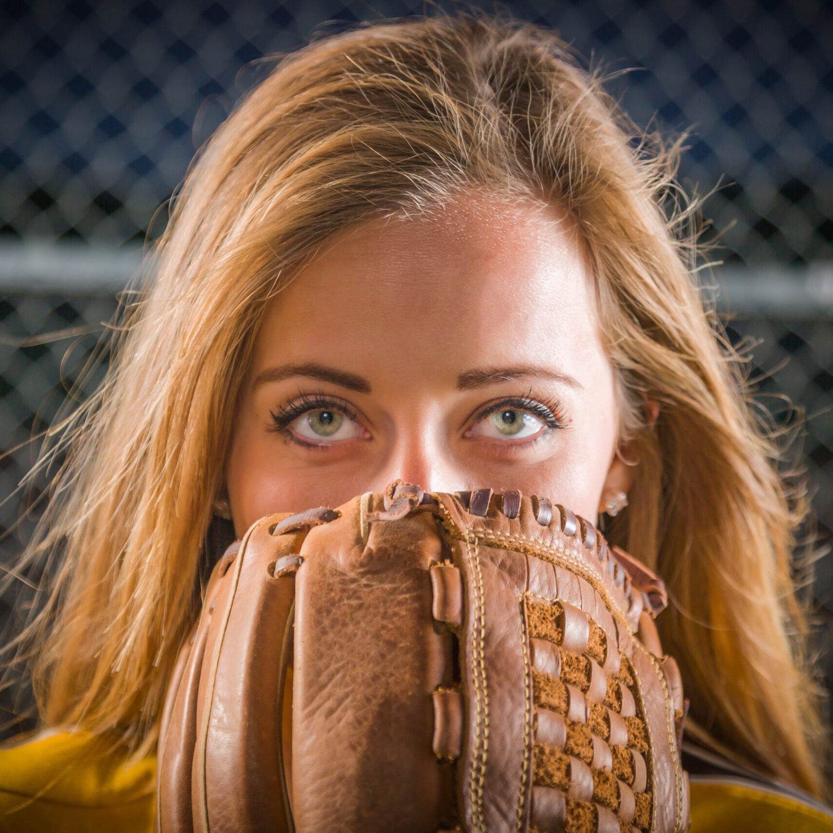 Dramatic Young Woman with Softball Glove Covering Her Face Outdoors.
